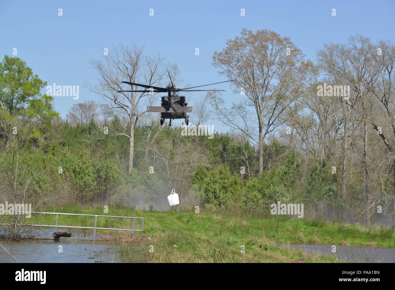 Louisiana National Guard Soldaten des 225Th Engineer Brigade verbinden 1.500 Pfund super Säcke zum Ende einer UH-60M Black Hawk zu schleudern werden von Piloten aus der Army Aviation Support Facility Nr. 3 in Pineville, La geladen, in Bayou Darrow südlich von Colfax in Grant Parish, La Die super Säcke werden verwendet, um den Fluss von Wasser, bei denen eine Steuerung fehlgeschlagen zu verlangsamen, 14. März 2016. Mehr als 1.400 Gardisten haben die Flut kämpfen über Louisiana unterstützt. (U.S. Army National Guard Foto von 1 Lt. Rebekka Malone) Stockfoto