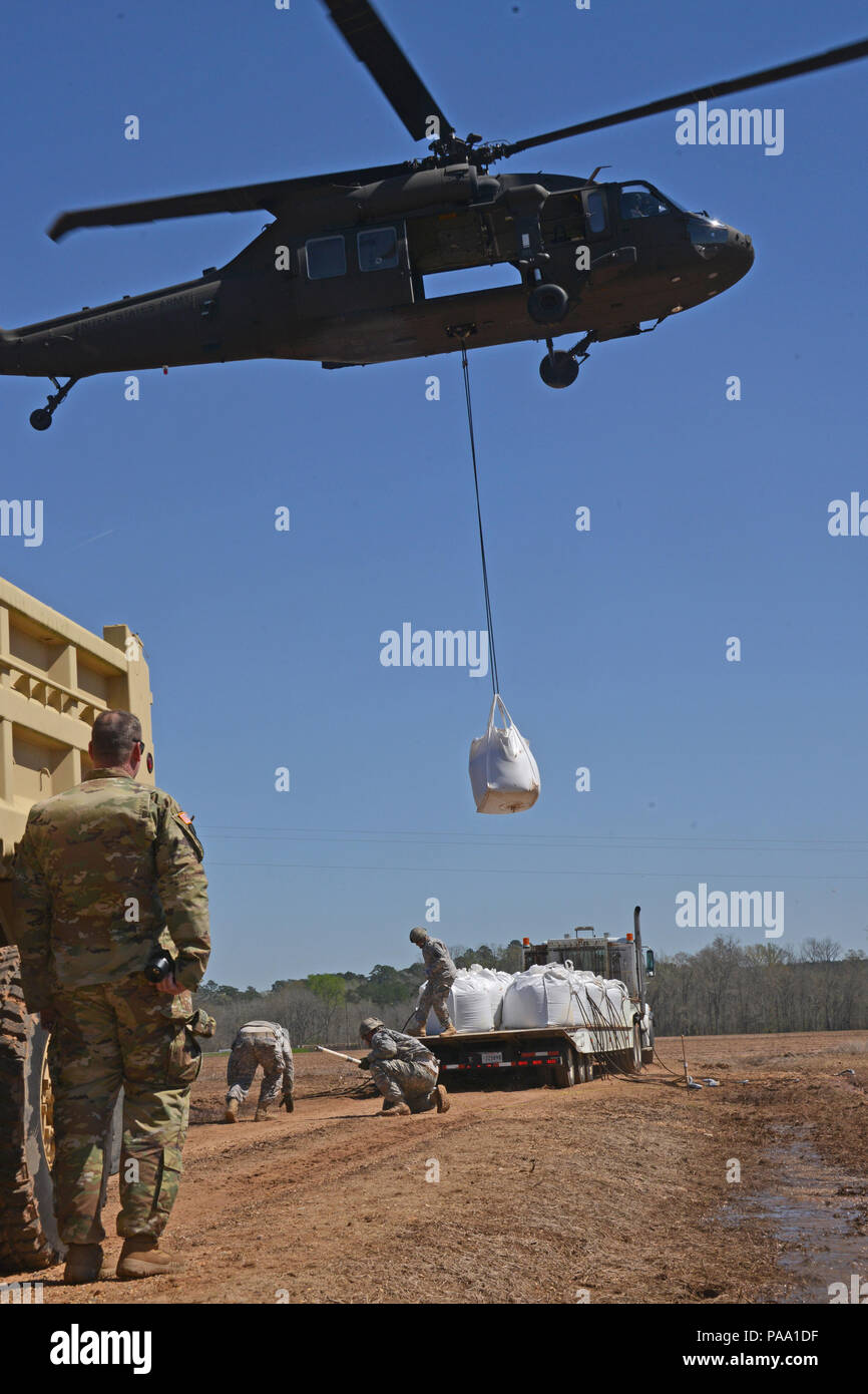 Louisiana National Guard Soldaten des 225Th Engineer Brigade verbinden 1.500 Pfund super Säcke zum Ende einer UH-60M Black Hawk zu schleudern werden von Piloten aus der Army Aviation Support Facility Nr. 3 in Pineville, La geladen, in Bayou Darrow südlich von Colfax in Grant Parish, La Die super Säcke werden verwendet, um den Fluss von Wasser, bei denen eine Steuerung fehlgeschlagen zu verlangsamen, 14. März 2016. Mehr als 1.400 Gardisten haben die Flut kämpfen über Louisiana unterstützt. (U.S. Army National Guard Foto von 1 Lt. Rebekka Malone) Stockfoto