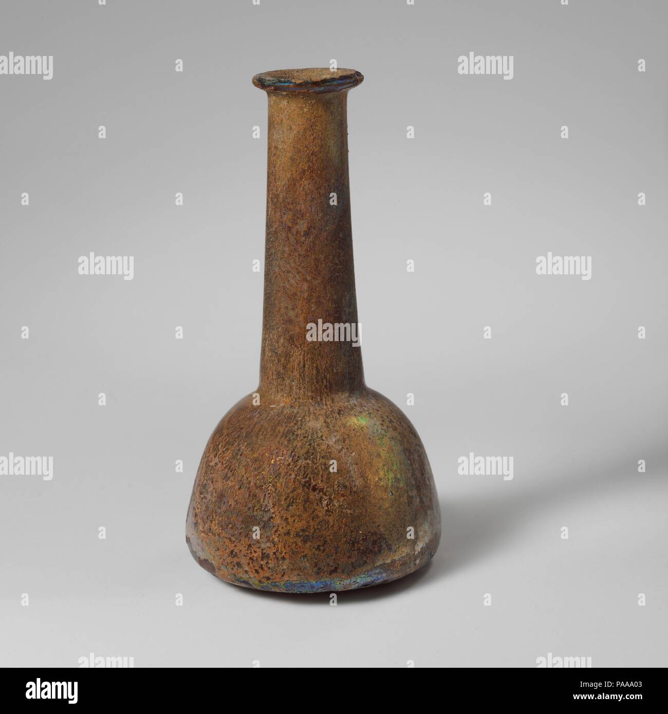 Glas Parfüm Flasche. Kultur: Roman. Abmessungen: 5 5/16 in. (13,5 cm) Andere: 2 11/16 in. (6,9 cm) Durchm. Von rim: 1 1/8 in. (2,9 cm). Datum: 2.-3.Jh. N.CHR.. Farblos mit hellblauen Farbton. Rim ausgeklappt, über, und in, und drückte in den Mund; zylindrische Hals nach unten erweitern und werkzeuggestützte in um Base; schräge Schulter; konischen Körper mit konvexen Seiten; runden Boden, in der Mitte abgeflacht. Intakt; pinprick blasen; einige tiefe Rillen und brillante Schillern; die meisten der Oberfläche mit cremig, irisierende Verwitterung abgedeckt. Verkrusteten Böden im Innenbereich. Museum: Metropolitan Museum of Art, New Y Stockfoto