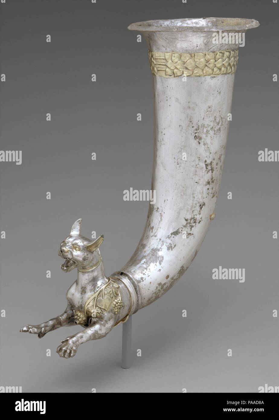 Rhyton endet in Zusammengeht eine wilde Katze. Kultur: PARTHISCHEN. Abmessungen: H.10 cm. (27,5 cm). Datum: Ca. Jahrhundert v. Chr.. Aufwändige Schalen, Tier-headed Trinkgefäße, und Rhytons - Schiffe, die eine Öffnung auf der Vorderseite, aus denen Flüssigkeit strömt - waren in hohem Grade in Altorientalischen Gesellschaft bewertet. Während die pre-Achämenidischen, Achämenidischen und Parthischen Perioden, Beispiele aus Silber, Gold und Ton waren in einem weiten Bereich, sowohl die Erweiterung nach Osten und Westen des Iran verwendet. Die Tiere auf diese Schiffe enthalten die Ram, Pferd, Stier, Steinbock, übernatürliche Kreaturen, und weibliche divinit Stockfoto