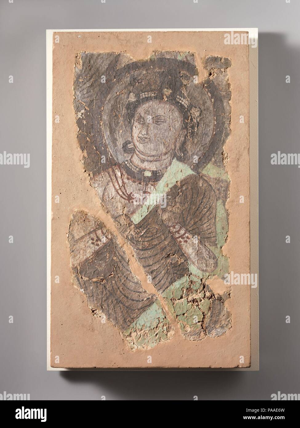 Sitzt Bodhisattva. Kultur: China (Xinjiang Uigurischen Autonomen Region). Abmessungen: 19 3/8 x 11 1/2 in. (49,2 x 29,2 cm). Datum: Ca. 6. bis 7. Jahrhundert. Die sitzende Bodhisattva in diesem Fragment einer Wandmalerei zeigt die Geste der Exposition oder Lehre mit seiner linken Hand. Während er die aufwendige Tiara trägt, Ohrringe, Halsketten, die typisch für einen Bodhisattva, seine Kleider sind monastischen Roben. Die grüne Farbe ist typisch für die Zentralasiatischen Malerei, während viel der Schwarzen nicht beabsichtigt war, sondern ist das Ergebnis der Oxidation von Pigmenten. Museum: Metropolitan Museum der Kunst, Neue Stockfoto