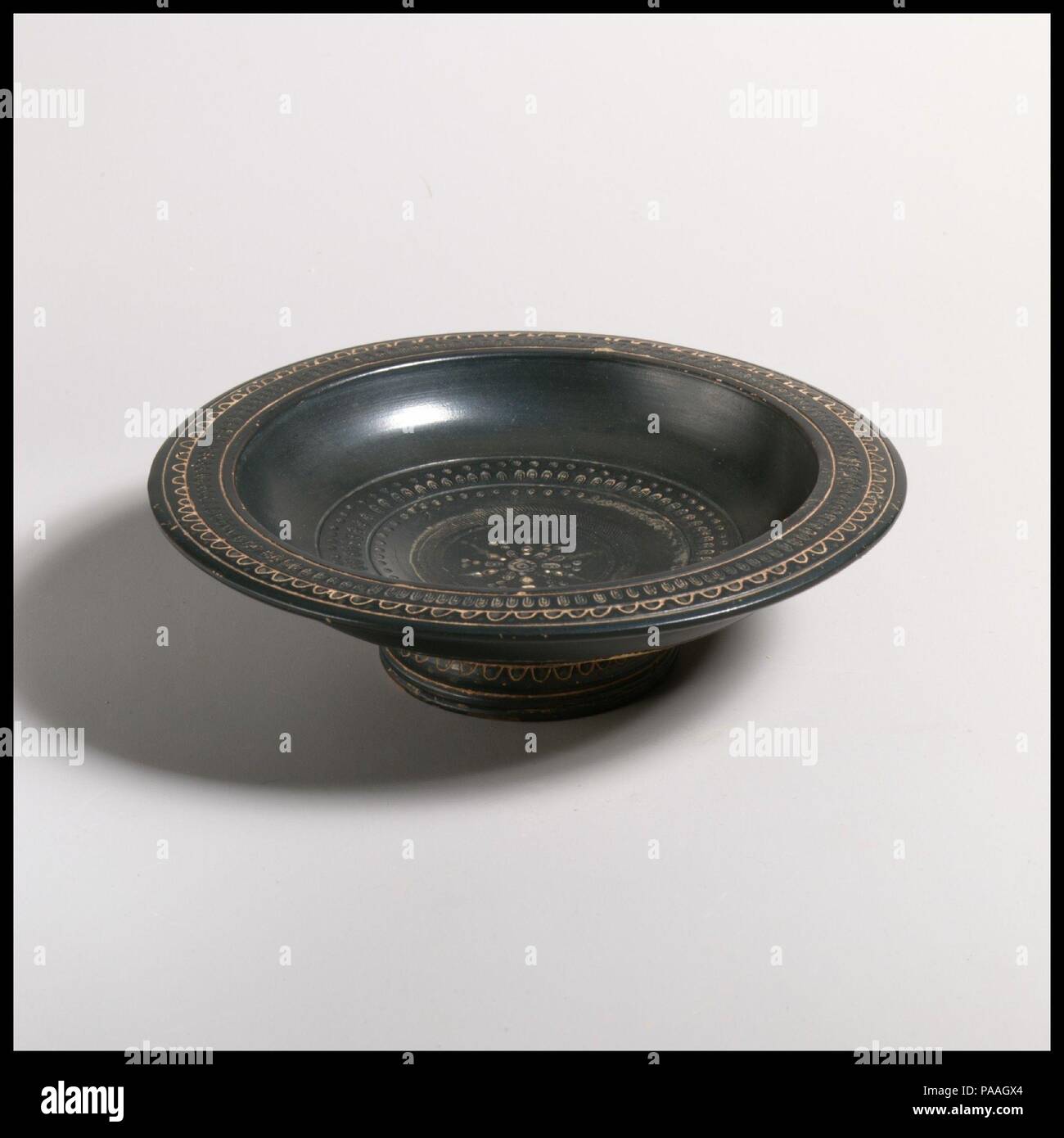 Terrakotta Teller. Kultur: Griechisch, Italienisch, Campanium, Teano. Abmessungen: Andere: 1 7/8 x 6 3/8 in. (4,8 x 16,2 cm). Datum: Ca. 330-300 V.CHR.. Flachen Teller mit Ring, mit eingeprägten Muster eingerichtet. Museum: Metropolitan Museum of Art, New York, USA. Stockfoto