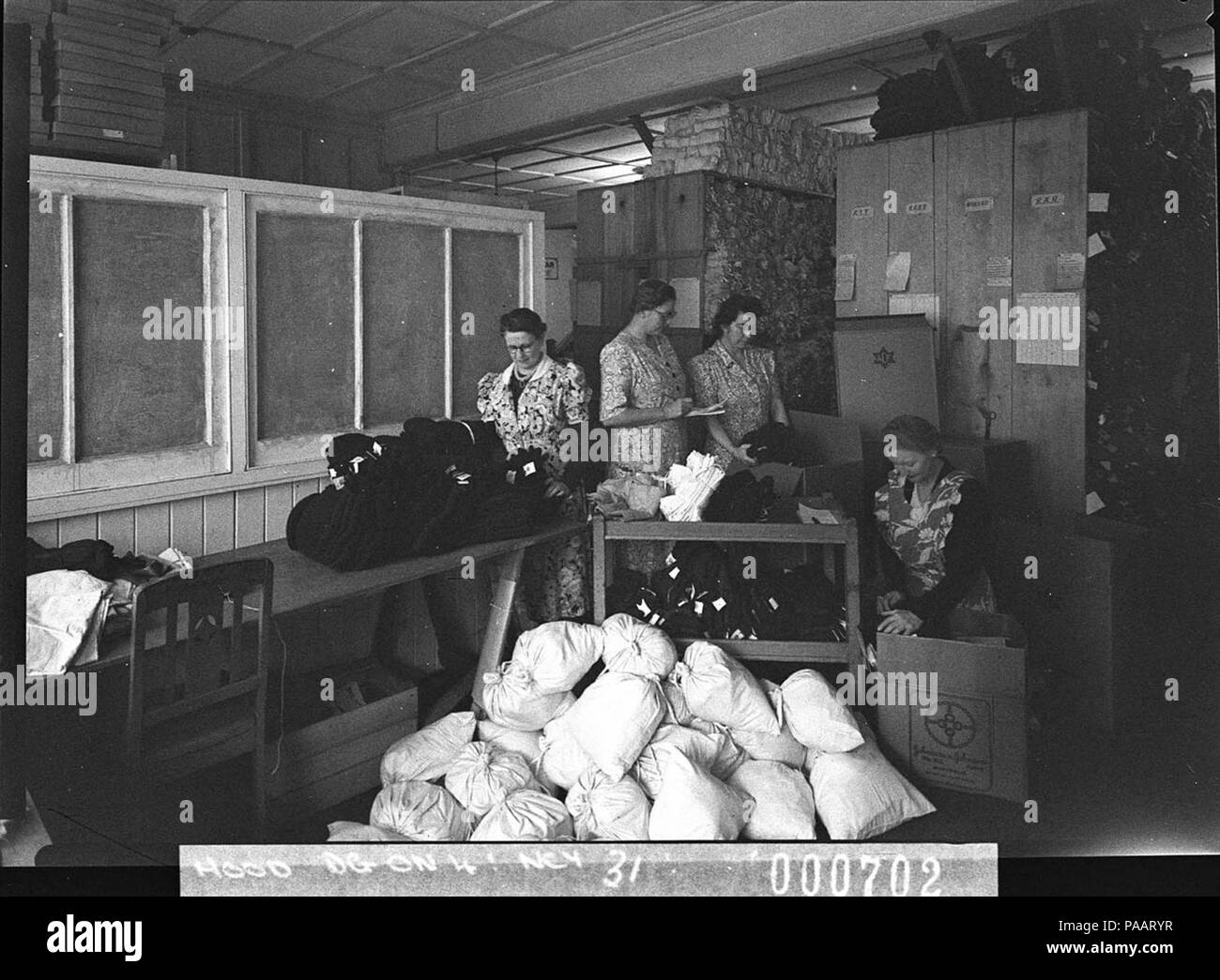 239 13205 SLNSW Frauen freiwillige packen Koffer mit Kleidung für Australische Komfort Fonds Stockfoto