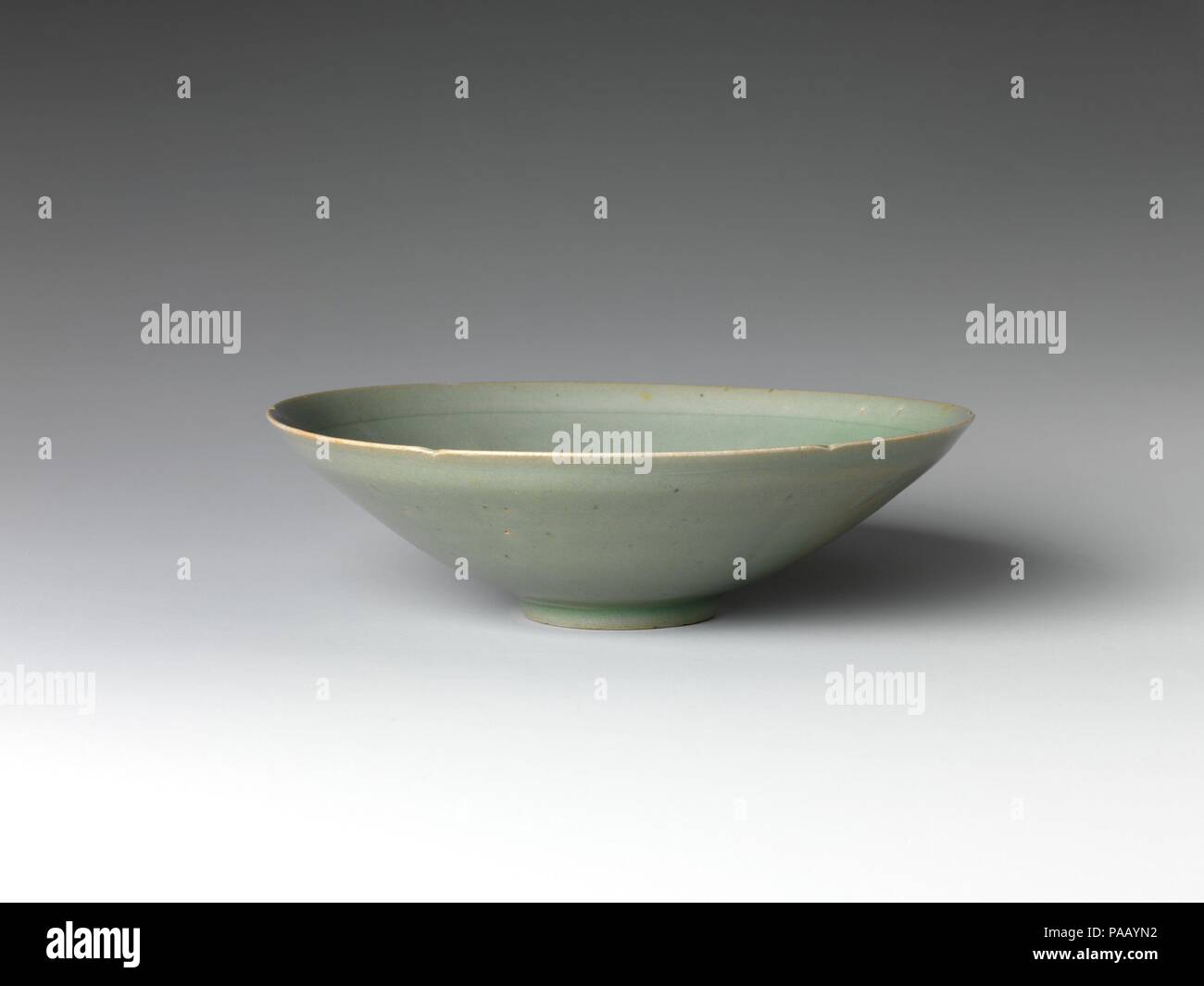 Six-Lobed Schüssel. Kultur: Korea. Abmessungen: H.2 1/8 in. (5,4 cm); Durchm. 7 3/8 in. (18,8 cm); Durchm. der Fuß 2. (5,1 cm). Datum: Anfang des 12. Jahrhunderts. Dieses 6-flügeligen Schüssel, geformt wie eine Blume, veranschaulicht die elegante Reinheit der frühen zwölften Jahrhunderts Goryeo Celadon. Seiner sauberen, minimalistischen Form ist nicht markierten durch Oberfläche Dekoration, für eine geschlitzte Ring um den inneren Rand der Schüssel zu speichern. Die Dünn vergossen Körper, grau-grünen Glasur, die drei kleinen Markierungen Sporn auf der Basis (Beweise dafür, dass die Schiffe beim Brennen gestapelt wurden) sind alle Merkmal der celadon aus dieser Zeit. Museum: Metrop Stockfoto