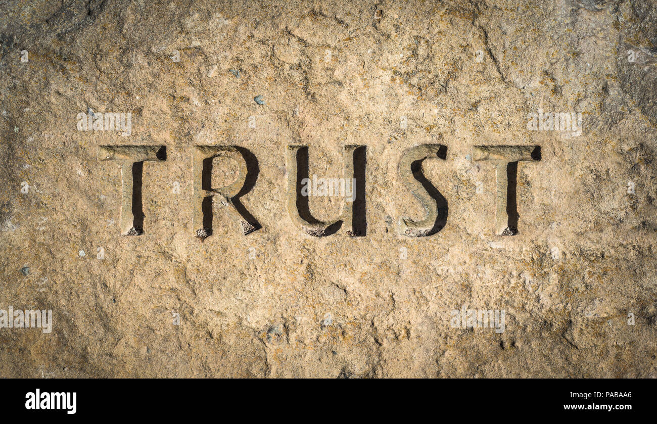 Konzeptionelle Bild des Wortes Vertrauen in Stein gemeißelt oder Rock Stockfoto