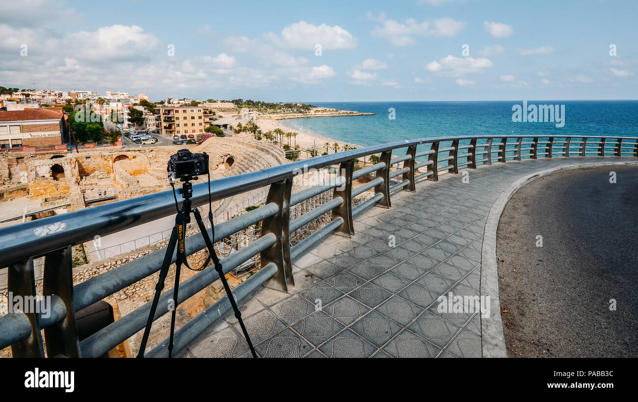Tarragona, Spanien - 11. Juli 2018: Illustrative Leitartikel der Nikon D800 DSLR-Kamera und Stativ mit Panoramablick auf das antike römische Amphitheater von Tarrag Stockfoto