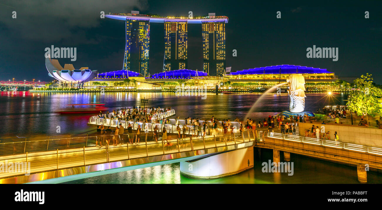 Singapur - 27. April 2018: Symbol von Singapur Merlion Statue, drei Türme von Marina Bay Sands, ArtScience Museum und Esplanade Bridge. Nachtleben in der Marina Bay Harbor in der Nacht. Stockfoto