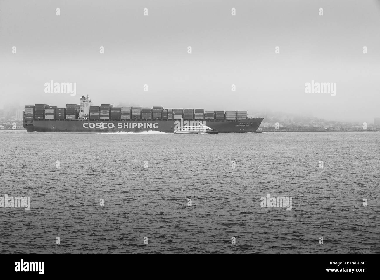 Schwarz-weiß-Foto des COSCO-Containerschiffs, CSCL BOHAI SEA, Abfahrt Oakland, San Francisco am frühen Morgen Nebel. Stockfoto