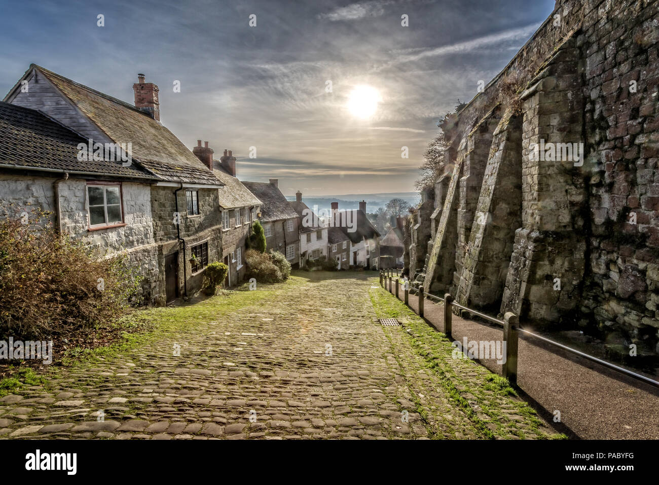 Berühmten Gold Hill in Shaftesbury mit Sonne im Himmel in Shaftebury, Dorset, Großbritannien am 3. Januar 2017 getroffen Stockfoto