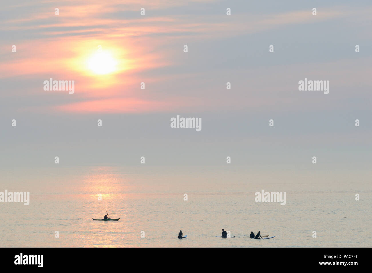 Silhouetten, Surfer und Meer Paddler auf dem ruhigen Nordsee am Abend, Norderney, Ostfriesische Inseln, Niedersachsen Stockfoto