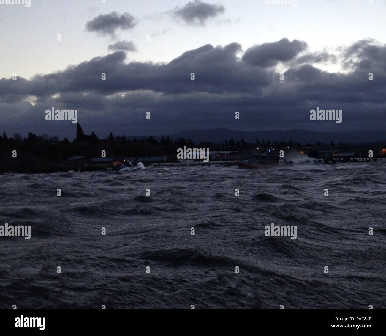 Eine Rettung boatcrew von der Coast Guard Station Bellingham, Washington, rettet drei Männer nach dem 57-Fuß-Schiff Bergen auf die Felsen in der Nähe von Squalicum Harbor, Washington, 10. März 2016 gewaschen. Die drei Männer waren sicher zu Station Bellingham transportiert, und man wurde zu PeaceHealth St. Joseph Medical Center nach der Materialverknappung Hypothermie und angeblich Leiden einer Fußverletzung. U.S. Coast Guard Foto von Petty Officer 3. Klasse Fernando Pratesi. Stockfoto