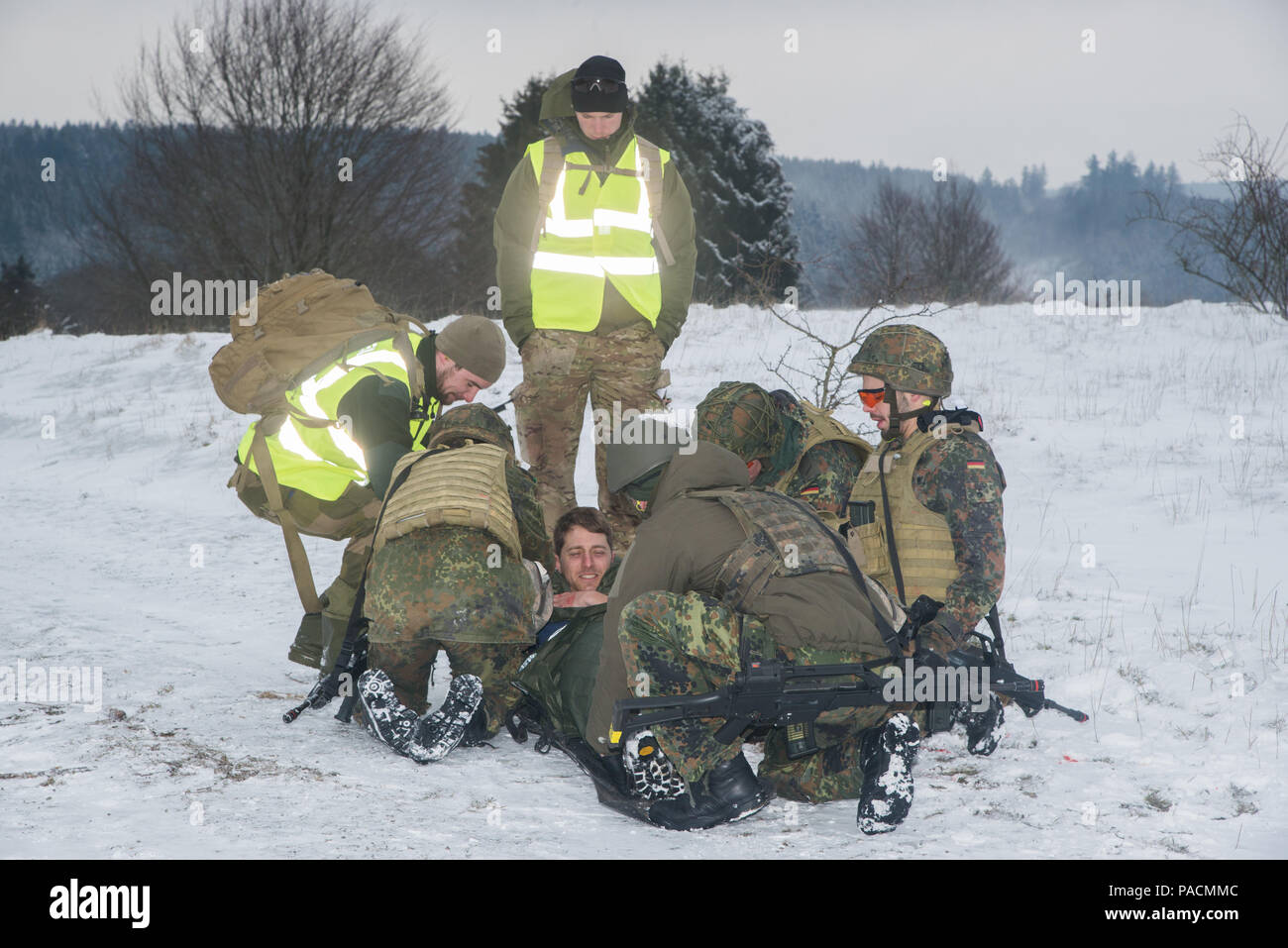 Ein Team von deutschen medizinischen Soldaten bereiten Sie eine internationale Soldat, Role player, mit simulierten Schusswunden für Evakuierung aus dem Schlachtfeld auch über die entsprechende Berechtigungsstufe Rescue System während Taktisches Unfallversicherung Care Kurs, dass multinationale Soldaten aus NATO-Ländern die Teilnahme an der internationalen Special Training Center Train the Trainer Kurs, in dem die Hälfte der Teilnehmer Tactical combat Casualty care Lernen und die andere Hälfte Lernen, die Bekämpfung der Unfall- Kurs zu unterrichten. Das Training wurde von General Staufer Kaserne, 16. März 2016 durchgeführt. (U.S. Armee Foto von visuellen Informationen Specialis Stockfoto