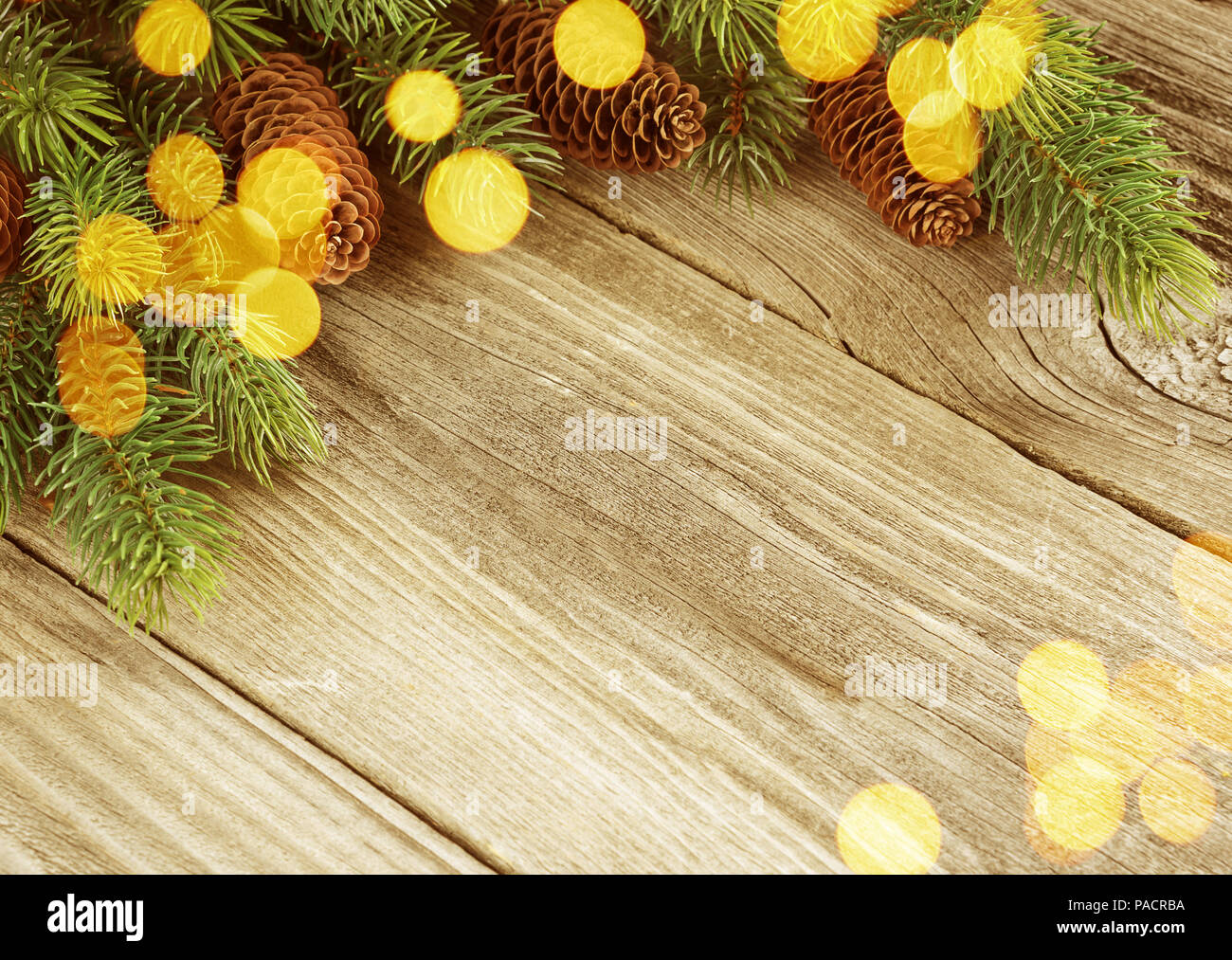 Weihnachten Rahmen aus Tannenzapfen, fichte Äste und Lichtblitze auf dem Hintergrund der alten unlackierte Holz; mit copy-Raum Stockfoto