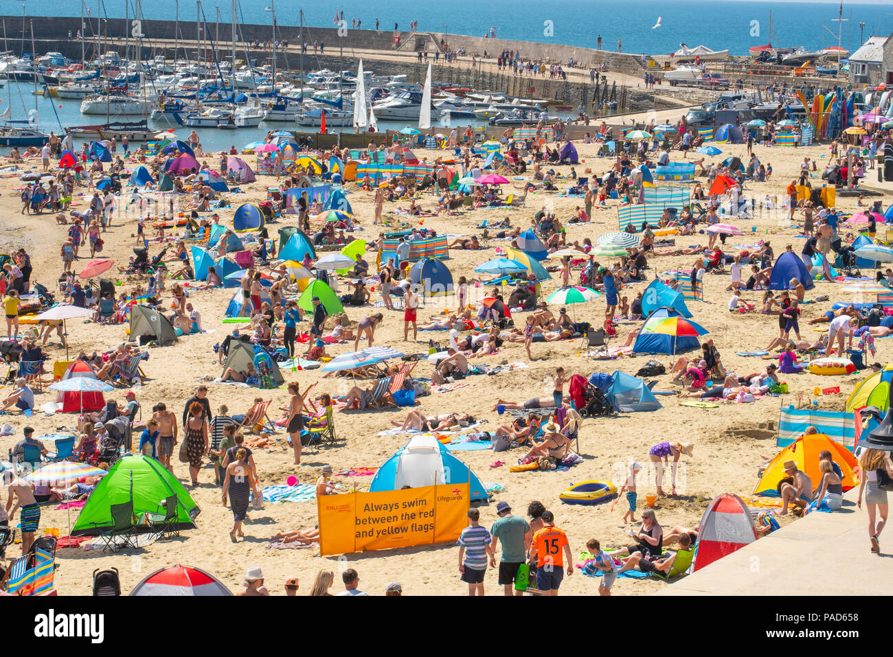 Lyme Regis, Dorset, Großbritannien. 22. Juli 2018. UK Wetter: Glühend heiße Sonne und blauen Himmel in Lyme Regis. Massen von Urlaubern und Sonnenanbeter in Scharen zu den Strand im Badeort von Lyme Regis am ersten Wochenende der Schulferien. Credit: Celia McMahon/Alamy leben Nachrichten Stockfoto