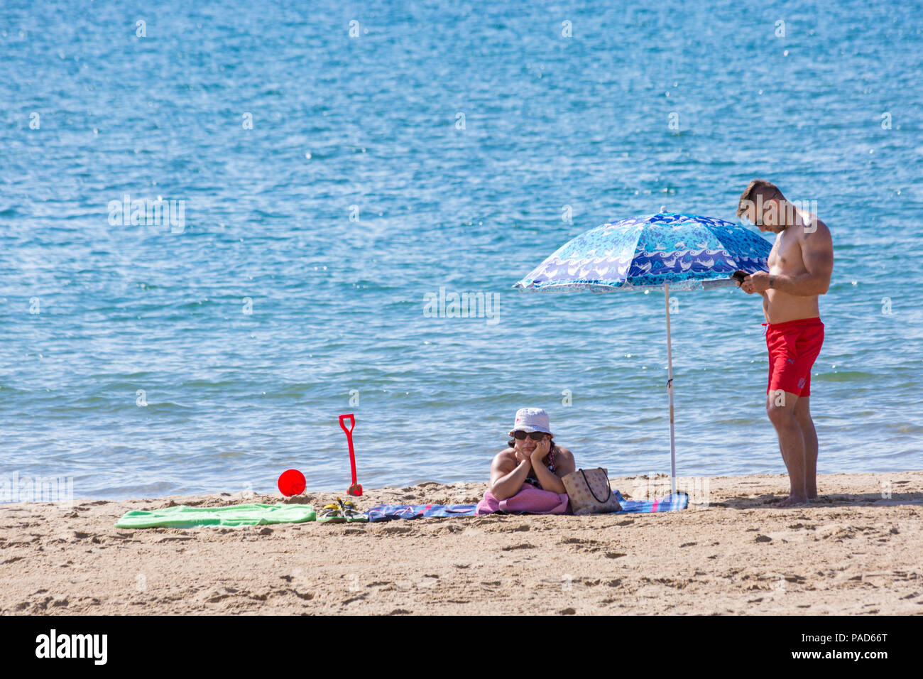 Bournemouth, Dorset, Großbritannien. 22. Juli 2018. UK Wetter: heiß und sonnig in Bournemouth Strände, als Sonnenanbeter Kopf ans Meer, um Sonne zu tanken. Paar Sonnenbaden auf Thebeach. Credit: Carolyn Jenkins/Alamy leben Nachrichten Stockfoto