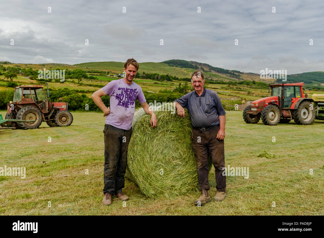 Ballydehob, West Cork, Irland. 22. Juli, 2018. Hollum basierte Bauern Michael Pat Ward und Noel Ward wrap Silage querhölzer auf einem anderen sehr heißen Tag in Irland. Das Wetter ist wechselhaft im Laufe der nächsten Tage mit Regen Prognose für die ganze Woche. Die Temperaturen an den hohen Teens fallen/Low 20 Celsius. Credit: Andy Gibson/Alamy Leben Nachrichten. Stockfoto