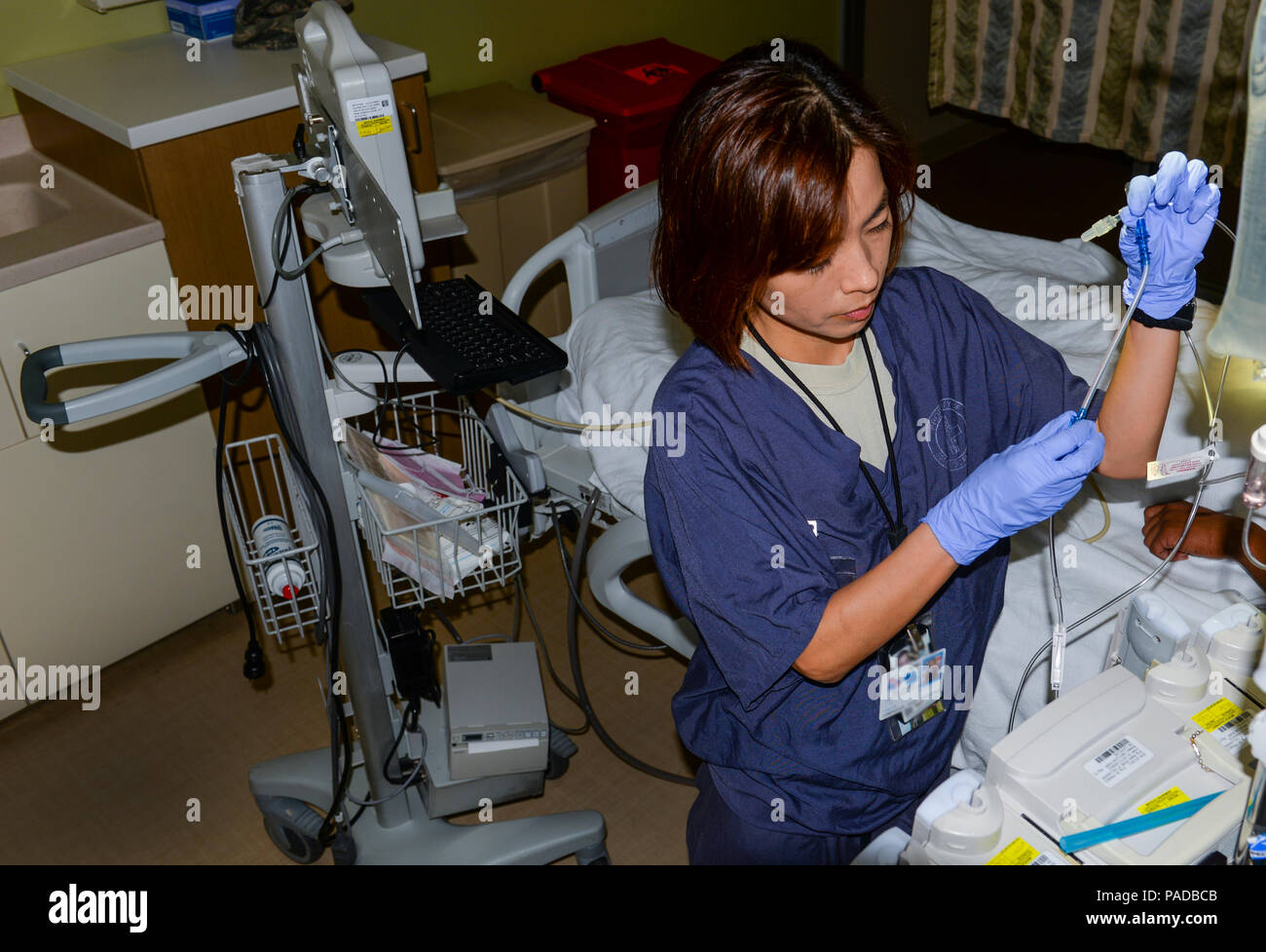 Kapitän min Choi, 99th Stationäre Operation Squadron klinischen Krankenschwester auf der Intensivstation, bereitet eine IV-Beutel an der Mike O'Callaghan Federal Medical Center am Nellis Air Force Base, Nev, 17. März 2016. Critical Care Krankenschwestern müssen in einer Vielzahl von High tüchtig sein - Ebene pflegerische Fähigkeiten. Sie müssen die Experten bei der Beurteilung von Patienten auf der Intensivstation, die Verwaltung, das Erkennen von Komplikationen und die Koordination mit anderen Mitgliedern der Critical Care Team. (U.S. Air Force Foto von Airman 1st Class Nathan Byrnes) Stockfoto