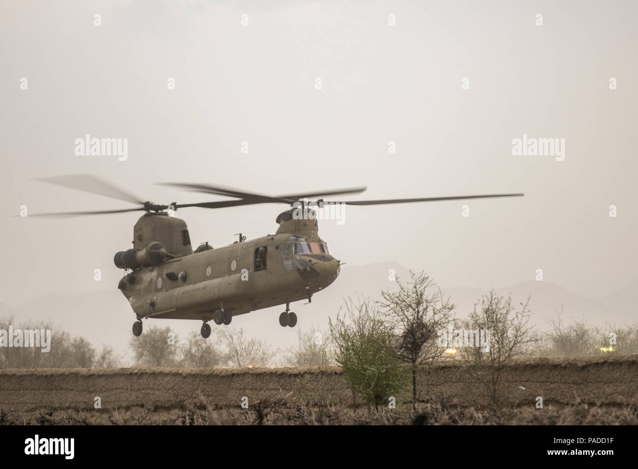 Eine CH-47 Chinook schwebt über eine F-16 Fighting Falcon Absturzstelle in Khanjar Khel, Provinz Parwan, Afghanistan, bevor slingloading Munition und Flugzeugteilen für den Transport zurück zum Flughafen Bagram, Afghanistan, 30. März 2016. Die F-16 stürzte nach dem Start und der Pilot sicher herausgenommen; seitdem ist die Basis abgeschlossen die Säuberung der Absturzstelle. Die Ursache wird derzeit untersucht. (U.S. Air Force Foto/Tech. Sgt. Robert Cloys) Stockfoto