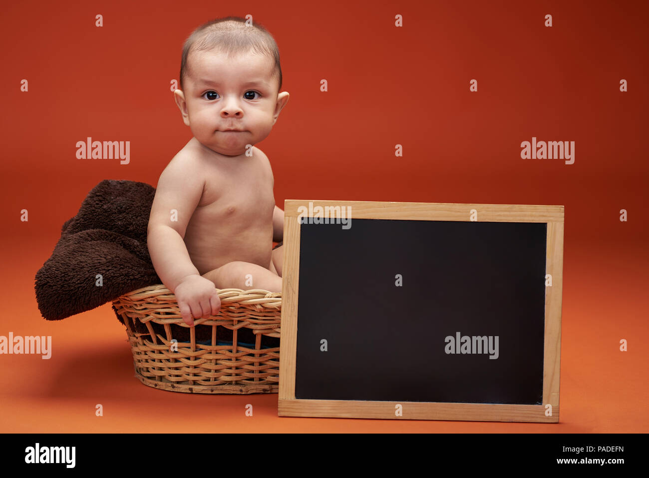 Baby boy in Korb mit klaren Board für Schreiben Stockfoto