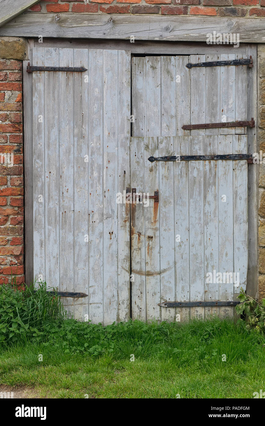 Rustikale Alte hölzerne Scheune Türen auf einem Bauernhof im späten Frühling im Norden von England, Yorkshire. Holz Textur Hintergrund. Stockfoto
