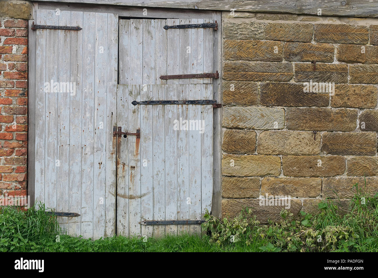Rustikale Alte hölzerne Scheune Türen auf einem Bauernhof im späten Frühling im Norden von England, Yorkshire. Holz Textur Hintergrund. Stockfoto