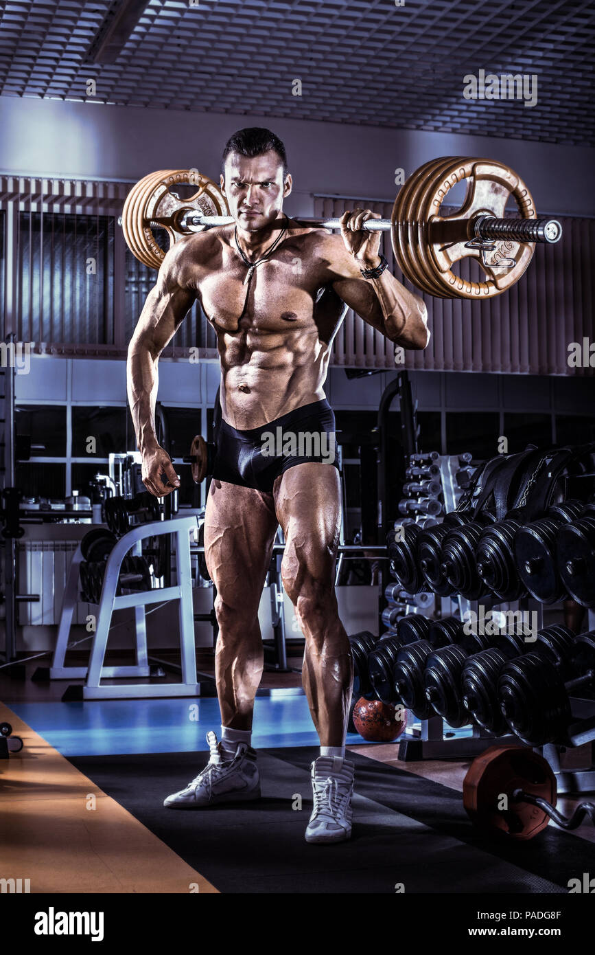 Guy Bodybuilder, Übung mit Gewicht in der Turnhalle ausführen, vertikale Foto, blau, violett Ton Stockfoto