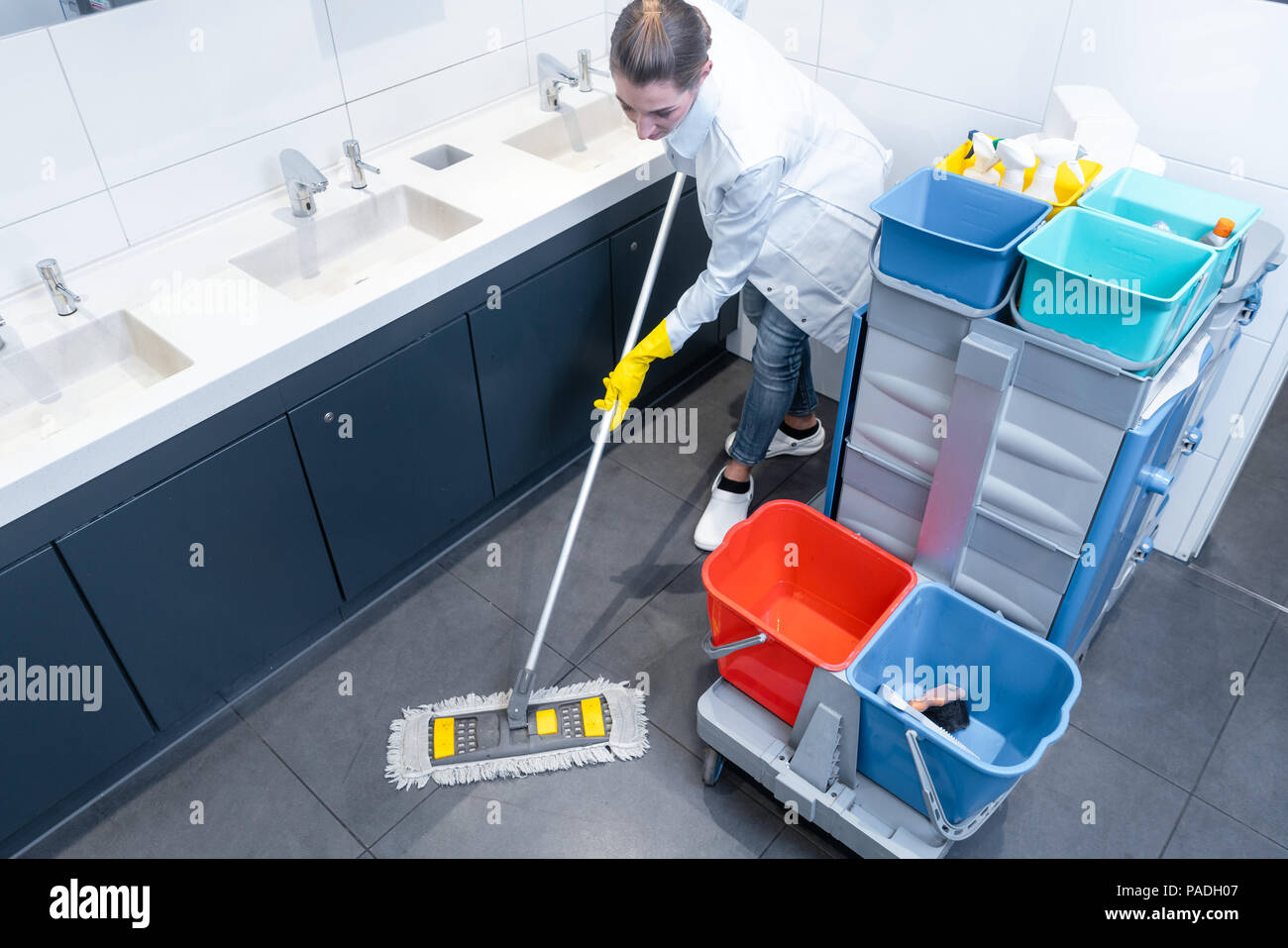 Putzfrau wischen den Boden in Toilette Stockfoto
