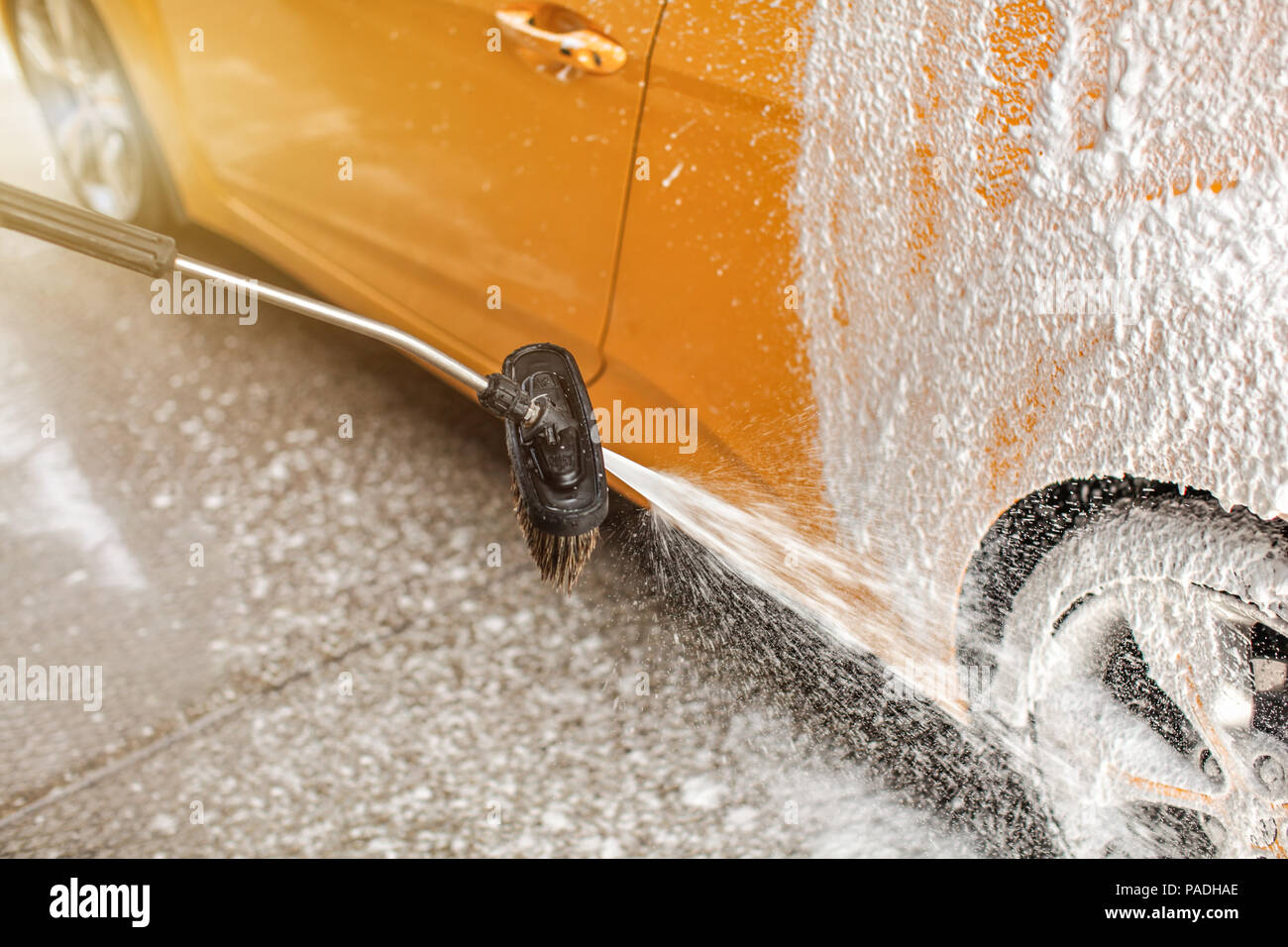 Schaum und Seife Sprühen aus der Pinsel auf Hinterrad des Auto in  Waschstraße gewaschen Stockfotografie - Alamy