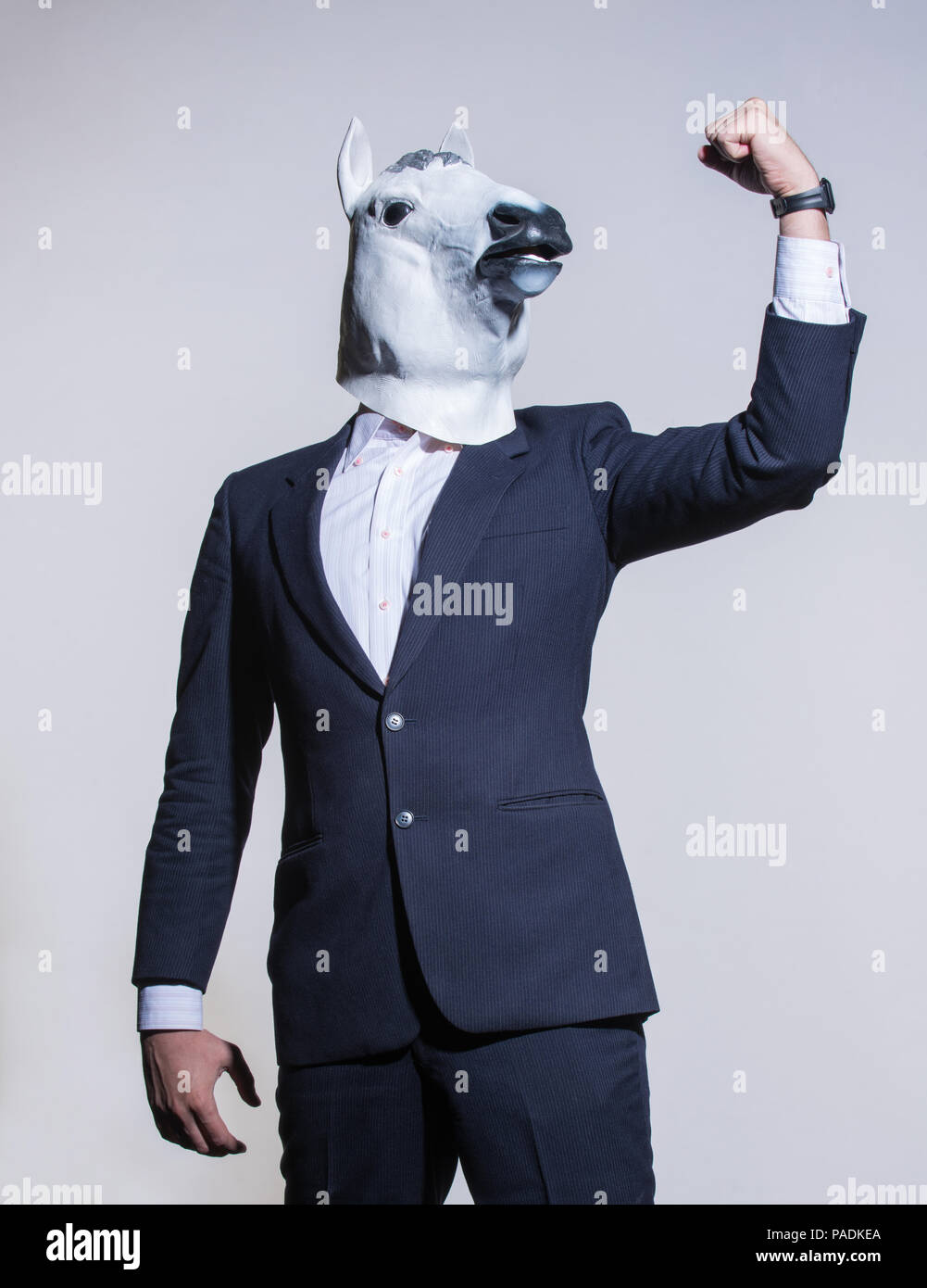 Ein Mann im Anzug und ein Pferd Maske auf einem hellen Hintergrund. Konzeptionelle geschäftlichen Hintergrund Stockfoto