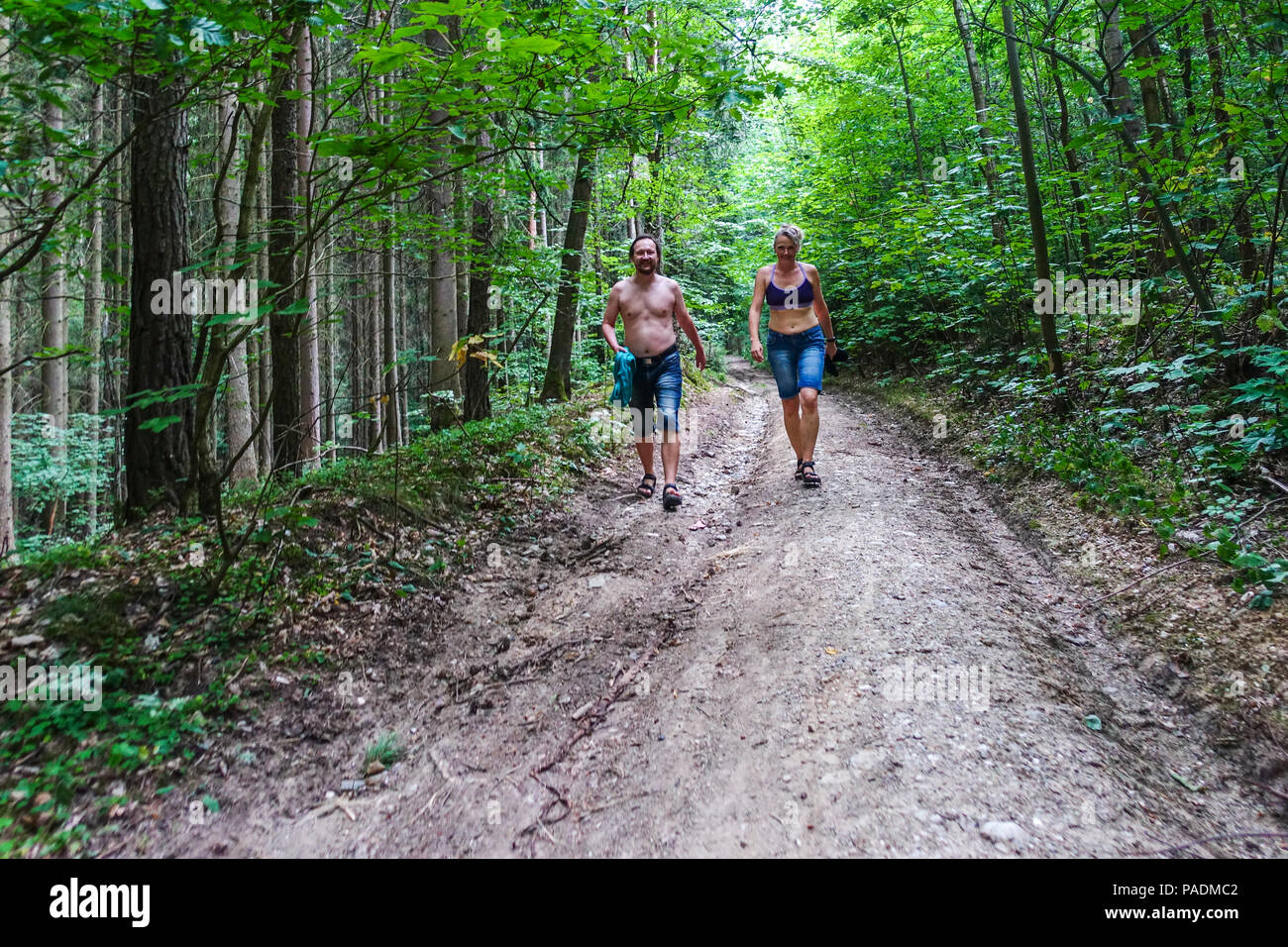 Paar, Mann und Frau, die zu Fuß auf einem Waldweg im Sommer Wärme, Tschechische Republik Stockfoto