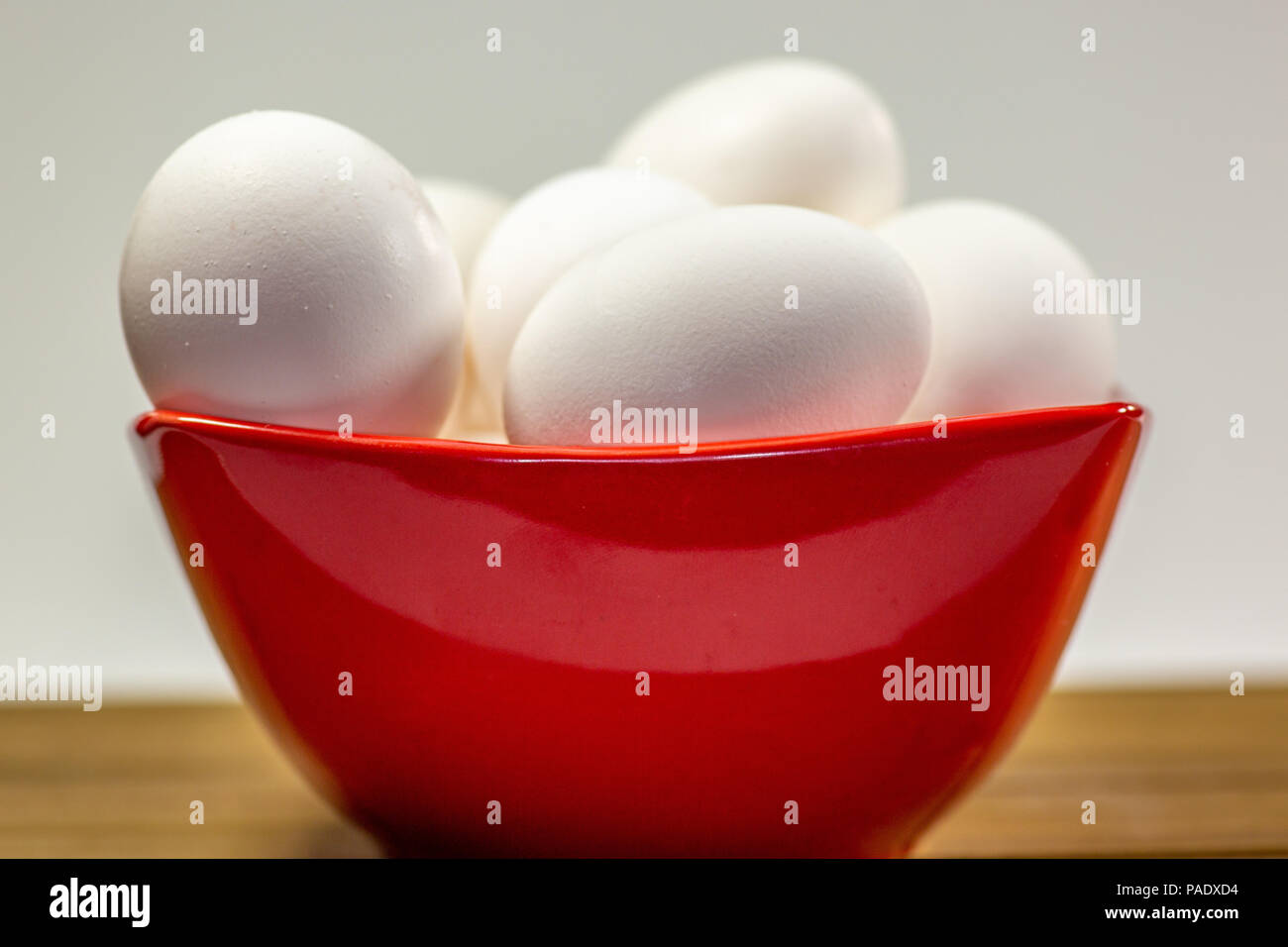 Eine Gruppe von Eiern in einer tiefen Rot Schüssel warten auf der Küchenchef Ihnen in einer Mahlzeit zu verwenden Stockfoto