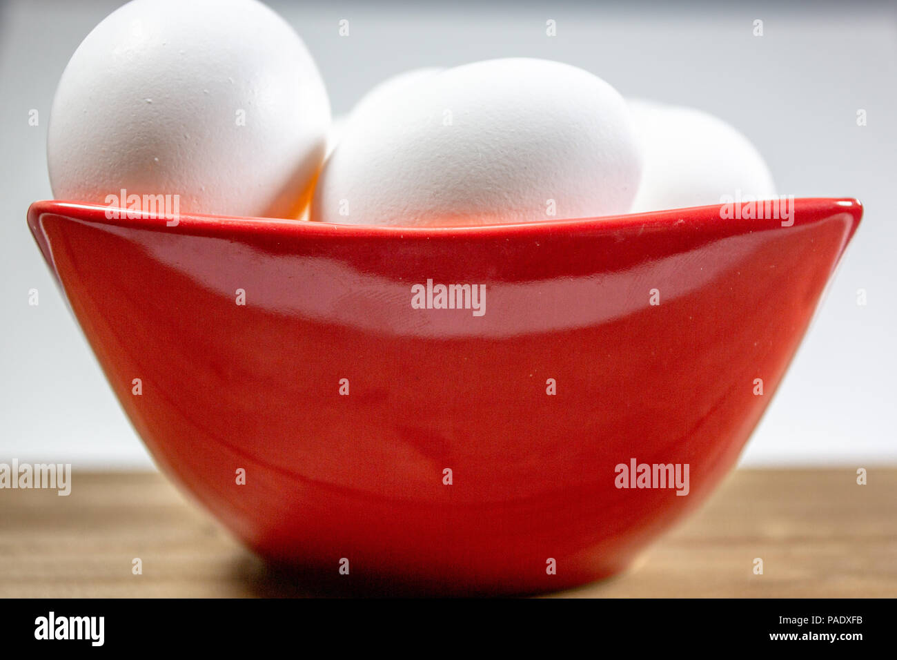Eine Gruppe von Eiern in einer tiefen Rot Schüssel warten auf der Küchenchef Ihnen in einer Mahlzeit zu verwenden Stockfoto