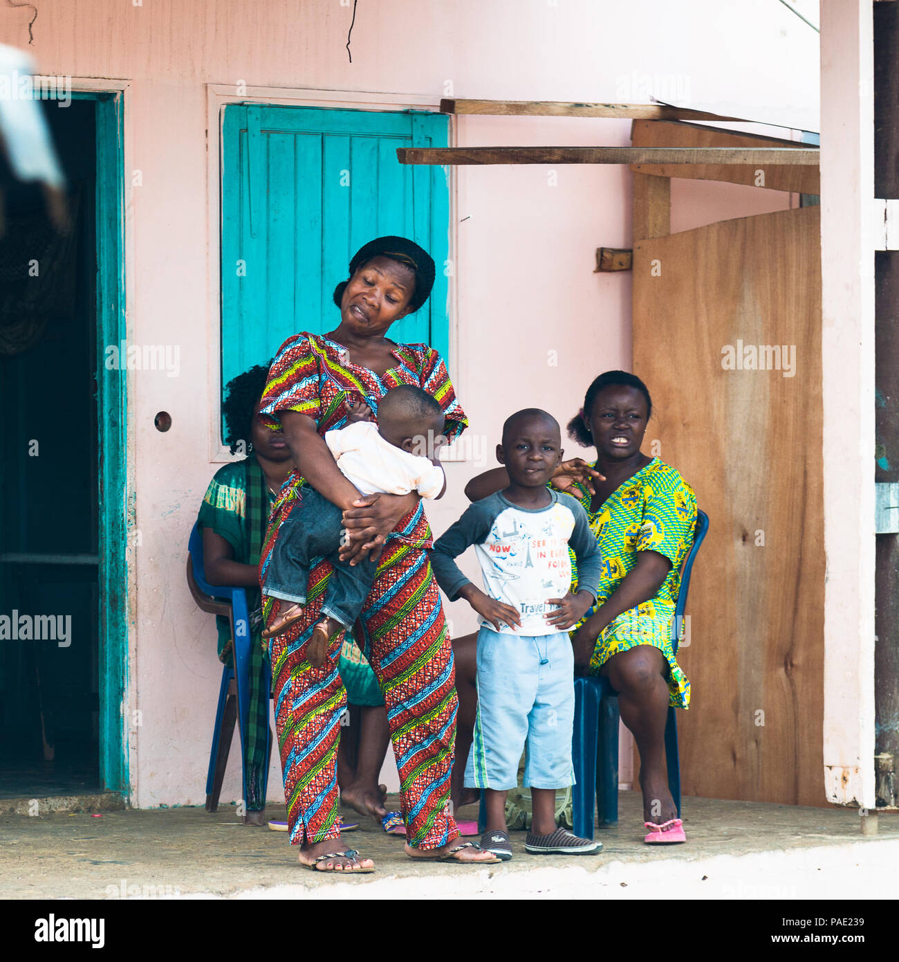 LIBREVILLE, Gabun - Mar 6, 2013: Unbekannter gabunischen Frau hält Ihr Baby und Ihre Freunde sitzen in Gabun, Mar 6, 2013. Menschen in Gabun leiden o Stockfoto
