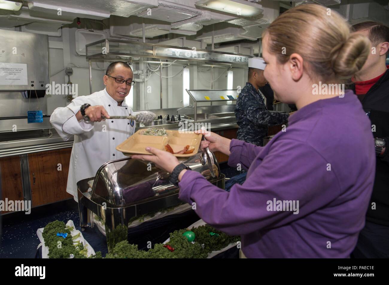 160327-N-TH 560-046 PAZIFISCHEN OZEAN (27. März 2016) - Kulinarische Specialist Master Chief Felipe Tubera serviert die Crew während eines speziellen Osterbrunch an Bord amphibisches Schiff USS BONHOMME RICHARD (LHD6). Bonhomme Richard ist der Leitung Schiff der Bonhomme Richard amphibische Gruppe bereit und freut - in den USA 7 Flotte Bereich eingesetzt. (U.S. Marine Foto von Mass Communication Specialist 3. Klasse Jeanette Mullinax/Freigegeben) Stockfoto