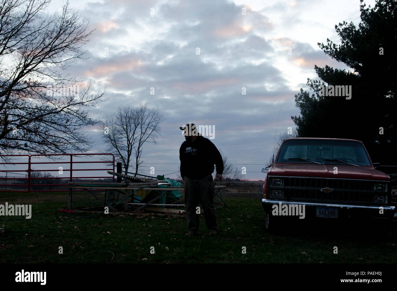 Joe Villines, eine Armee Sgt. Mit der US-Army Reserve schließt die Arbeit bevor er Tageslicht verliert, auf seiner Farm in Cummings, Iowa, 18. März 2016. Villines verwaltet die Balance zwischen seinen militärischen Pflichten zu finden, seine zivile Karriere mit der Abteilung Angelegenheiten der Veteranen, Vaterschaft, und eine wachsende Leidenschaft in ländlichen Landwirtschaft. Joe nimmt sein Wissen über die traditionelle Landwirtschaft und immer ein Mann auf dem Boden, und in den Prozess zurück zu seinem lokalen Gemeinschaft geben. (U.S. Armee finden Foto von Brian Godette, USARC Public Affairs) Stockfoto