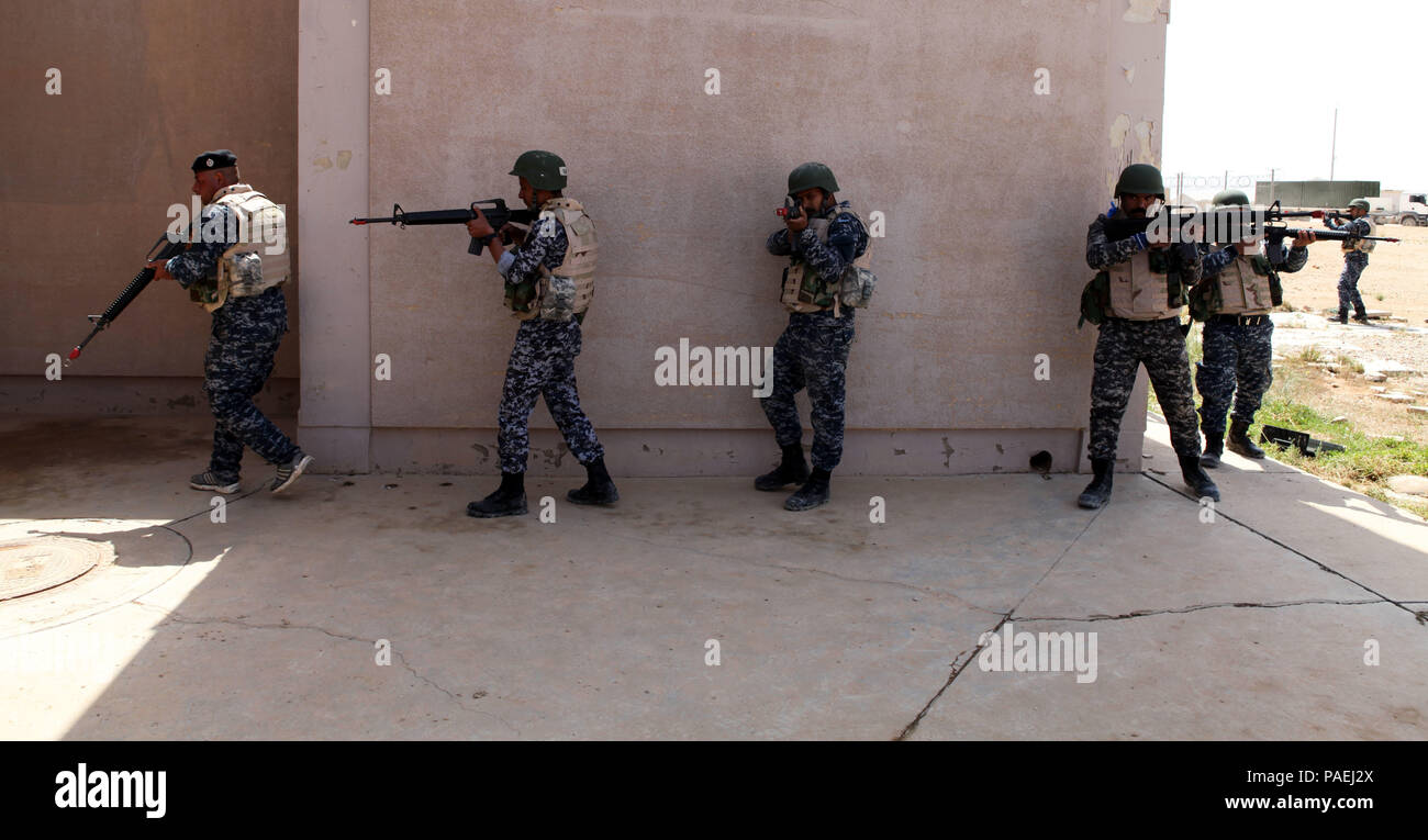 Irakische Bundespolizei Mitglieder Line up außerhalb eines Gebäudes in Vorbereitung einer gewaltsamen Eindringen bei militärischen Operationen in urbanem Gelände Ausbildung bei Al Asad Air Base, Irak, 28. März 2016 zu führen. Die kleine Einheit militärischen Taktik Schulung ist Teil des Gebäudes der Kapazitäten (BPC) Mission, die militärischen Fähigkeiten der irakischen Sicherheitskräfte (ISF) der Islamischen Staat im Irak und der Levante zu kämpfen. Durch die ISF durch beraten und unterstützen, und BPC-Missionen, die Combined Joint Task Force - Betrieb die Lösung der multinationale Koalition unterstützt die Regierung von Ira Stockfoto