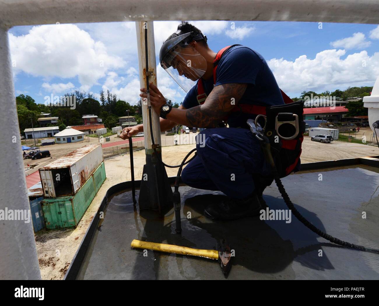 Petty Officer 3rd Class Edwin Chun, ein Schaden controlman, unclogs ein Deck drain onboard USCGC Kukui (WLB 203), 17. März 2016. Als Schaden controlman, Chun für Wasserdichtigkeit zuständig ist, Notfallausrüstung mit Brandbekämpfung und Hochwassergefahren, Sanitär Reparaturen sowie Schweißen Fertigung und Reparaturen. (U.S. Coast Guard Foto von Petty Officer 2. Klasse Melissa E. McKenzie/Freigegeben) Stockfoto