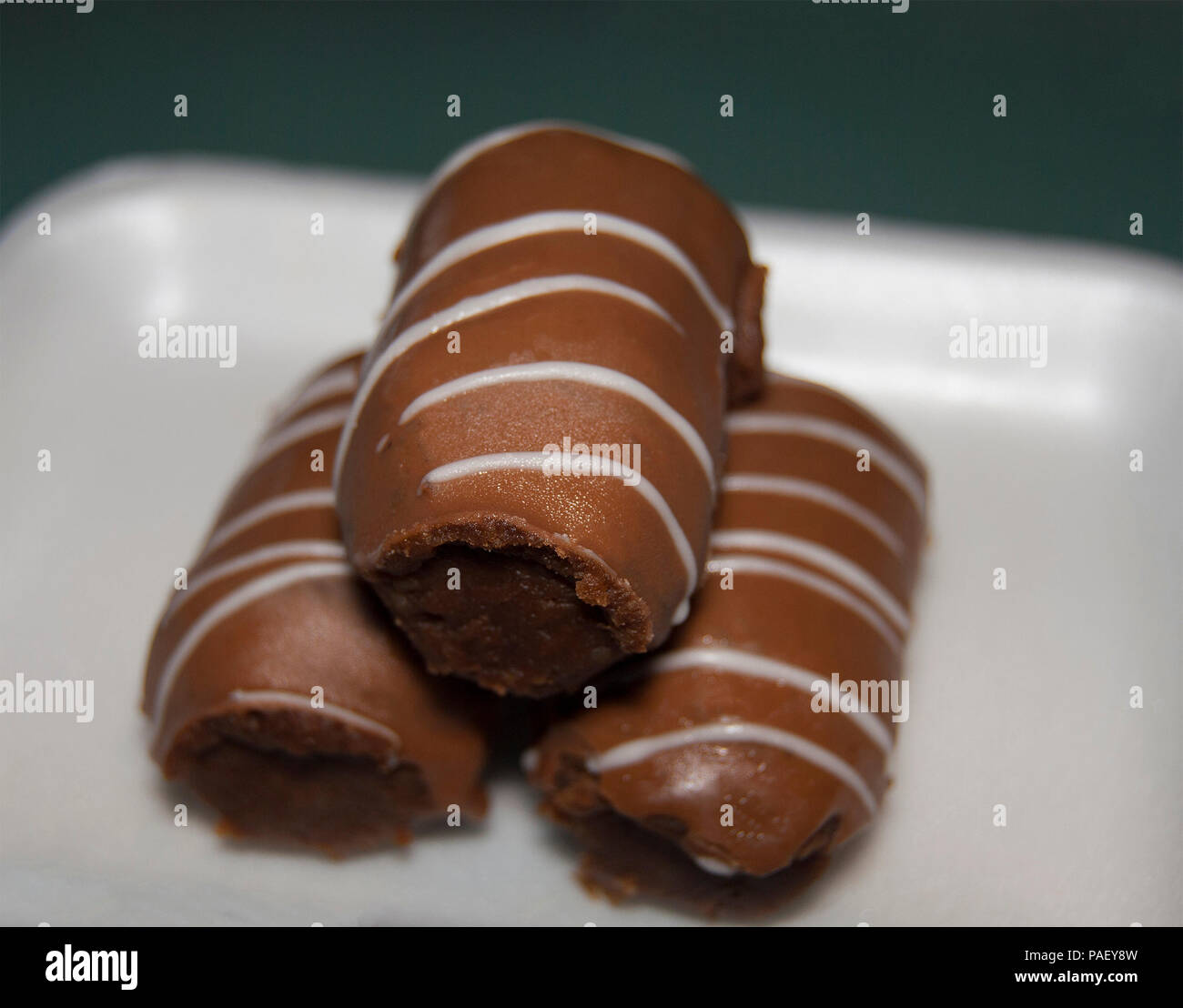Drei Kuchen "Kartoshka" liegen übereinander auf einen weißen rechteckigen Platte. Stockfoto