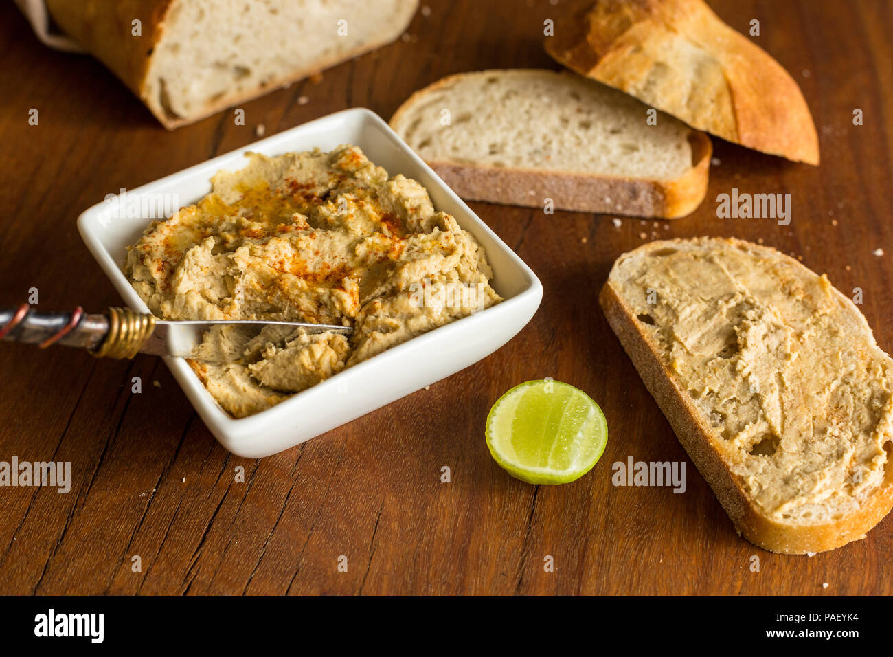 Hummus mit sauerteigbrot auf hölzernen jarrah Board Stockfoto