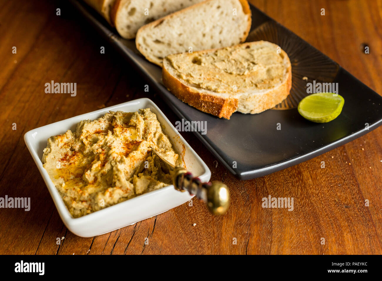 Hummus mit sauerteigbrot auf hölzernen jarrah Board Stockfoto