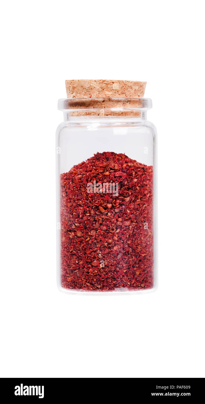 Sumac in einer Glasflasche mit Korken Stopfen, auf weissem isoliert. Stockfoto