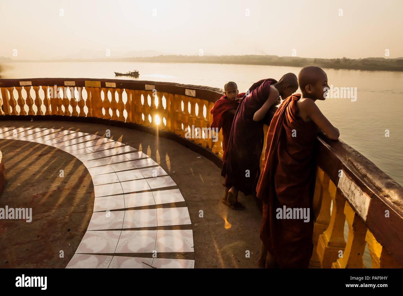 Drei Mönche an der Pagode mit letzten Sonne entlang des Flusses in der Hpa-an, Myanmar glänzte Stockfoto