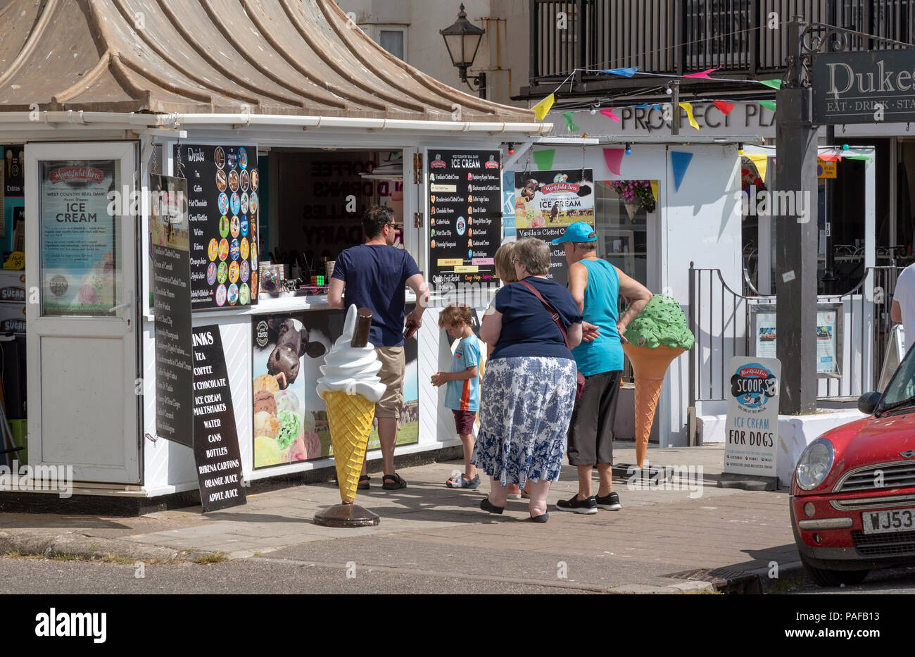 Honiton, Devon, Großbritannien. Urlauber kaufen Eis an der Küste Stockfoto