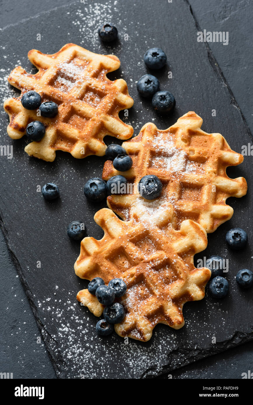Belgische Waffeln serviert mit Blaubeeren auf Schiefer. Ansicht von oben Stockfoto