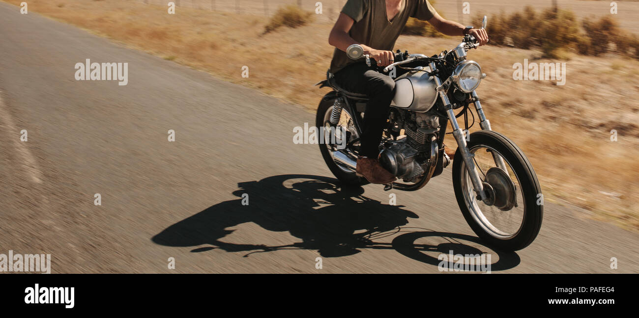 Mann reiten Motorrad auf der Landstraße. 7/8 Schuß des Menschen auf dem Mountainbike schnell. Stockfoto