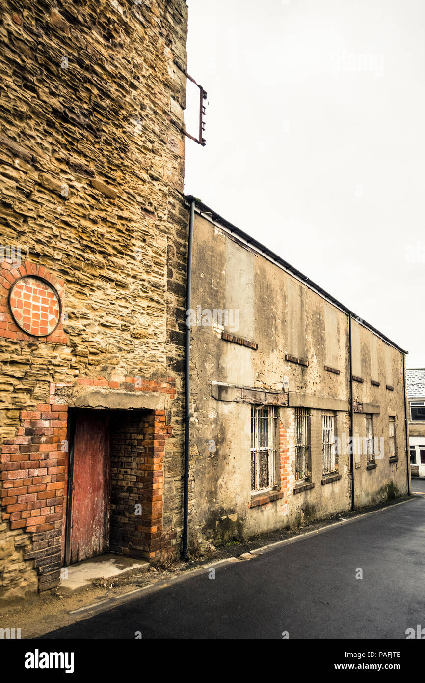 Altes Gebäude mit vergitterten Fenstern und abgenutzt und verwitterten Wänden Stockfoto