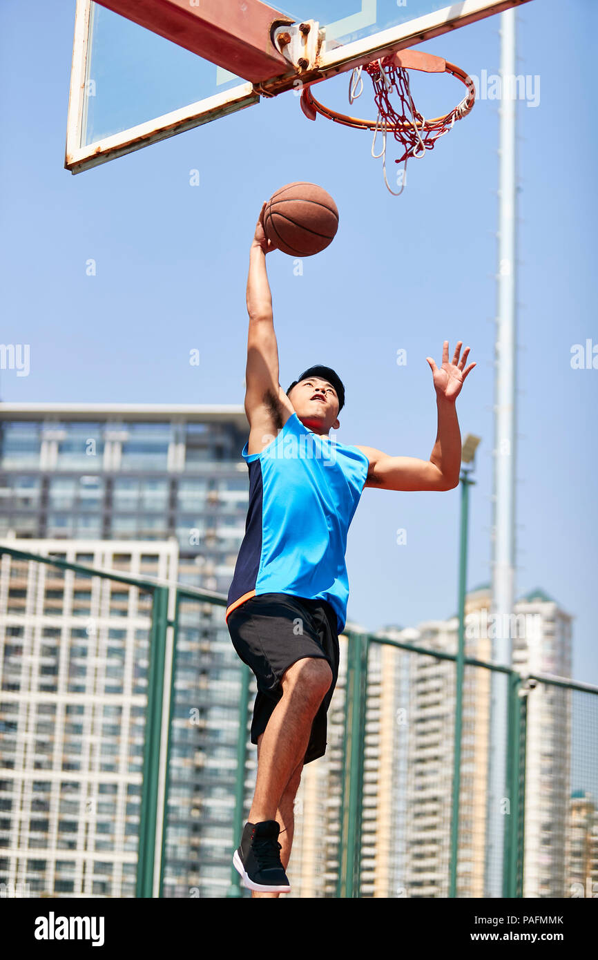 Jungen asiatischen nach dunking Basketball im Freien Gericht. Stockfoto