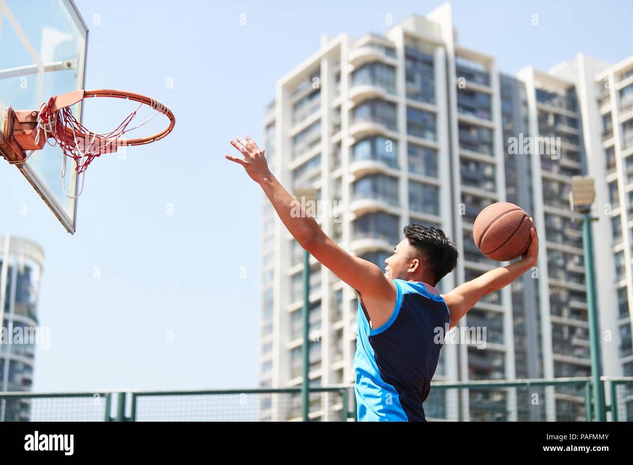Jungen asiatischen nach dunking Basketball im Freien Gericht. Stockfoto