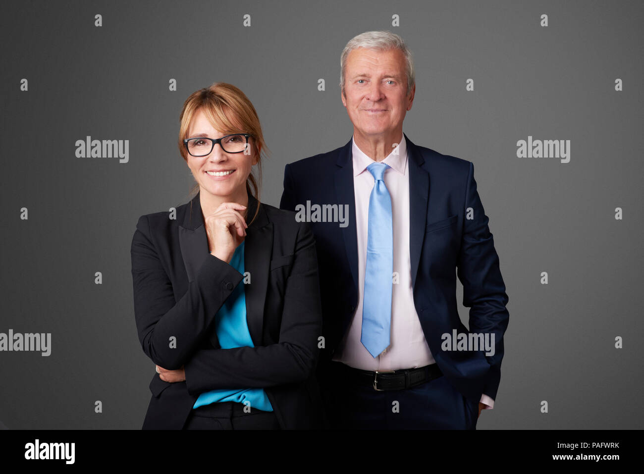 Eine attraktive Geschäftsfrau und mittleren Alters eine exectuive Professionelle man stehend an isolierten Hintergrund. Stockfoto