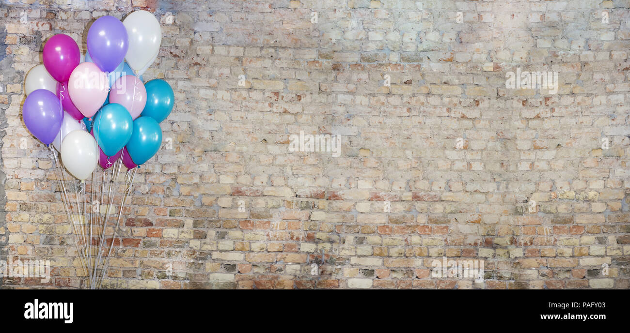 Eine Menge Luftballons an der Vorderseite der Ziegel Wand. Stockfoto
